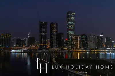 a view of a city skyline at night at LUX The Bays Edge Canal View Suite in Dubai