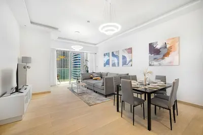 a living room with a table and a couch at Medore Brand New 1 and a half Bedroom apartment in Dubai