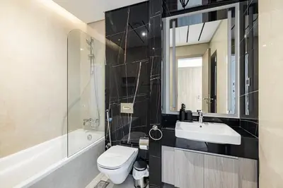 a bathroom with a toilet and a sink and a mirror at Medore Brand New 1 and a half Bedroom apartment in Dubai