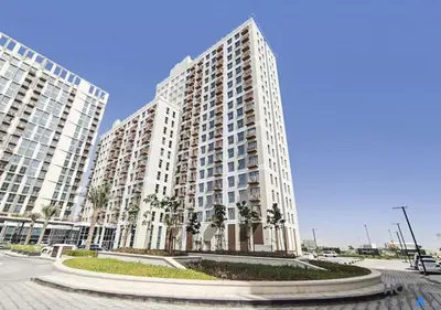 a large apartment building with palm trees in front of it at Lux 1BR Near Dubai Hills Mall in Dubai