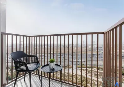 a chair and a table on a balcony with a view at Stunning 1bed In Dubai Hills in Dubai