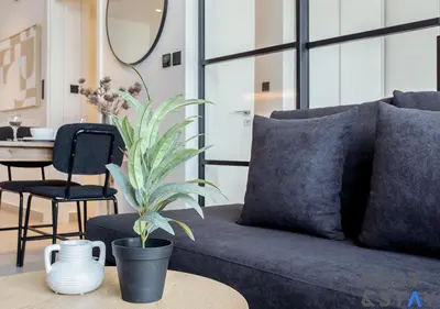 a living room with a couch and a plant on a table at Elegant 1BR In Collective, Dubai Hills in Dubai