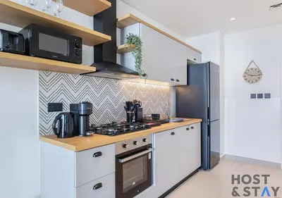 a kitchen with a stove and a microwave at Elegant 1BR In Collective, Dubai Hills in Dubai
