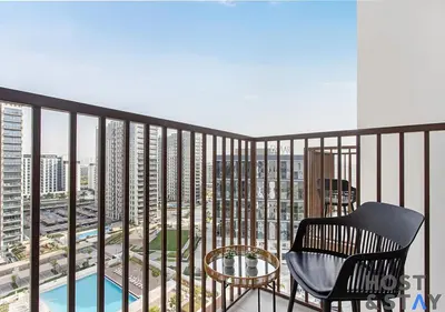 a balcony with a chair and a table at Elegant 1BR In Collective, Dubai Hills in Dubai