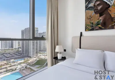 a bedroom with a bed and a large window at Amazing 1BR in Collective2, Dubai Hills in Dubai