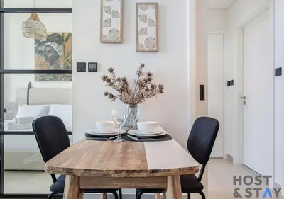 a dining room with a wooden table and chairs at Amazing 1BR in Collective2, Dubai Hills in Dubai