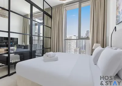 a bedroom with a large white bed and a desk at Amazing 1BR in Collective2, Dubai Hills in Dubai