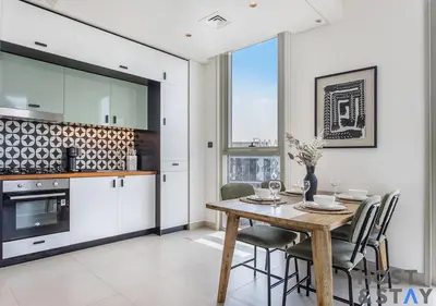 a kitchen and dining room with a wooden table and chairs at Modern 2BR Gem In Dubai Hills in Dubai