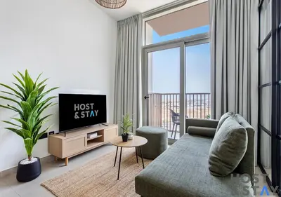 a living room with a couch and a tv at Serene 1BR Getaway In Collective in Dubai