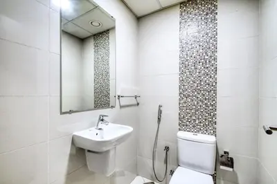a bathroom with a sink and a toilet and a mirror at ShoresInn - Spacious unit with Dubai Marina View in Dubai