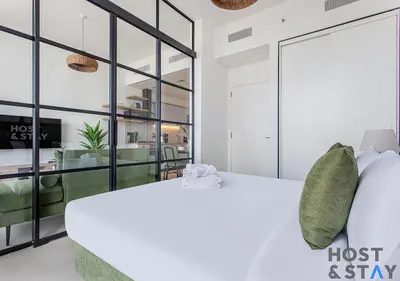 a bedroom with a bed and a glass wall at Stylish 1BR Apt In Collective 2 in Dubai