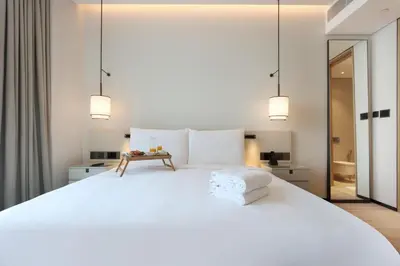 a bedroom with a large white bed with two lights at 1BHK with Marina and Partial Sea Views in Dubai