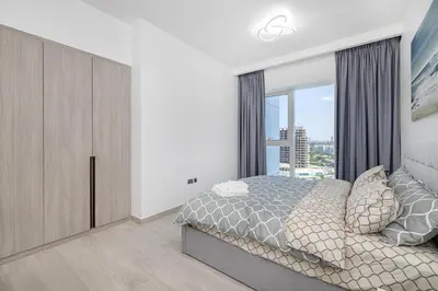 a bedroom with a bed and a large window at Medore Brand New Flat in Dubai - 8 in Dubai