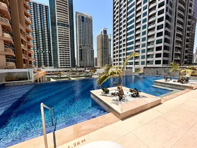 a large swimming pool in a city with tall buildings at Medore Entire Brand New Flat in Dubai in Dubai