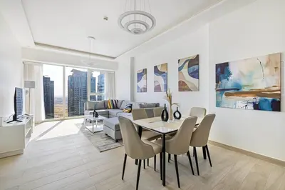 a white living room with a table and chairs at Medore High Floor Brand New Apartment - 27 in Dubai