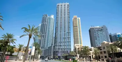 a group of tall buildings in a city with palm trees at Burj View Infinity Pool - Dubai Mall Connection in Dubai