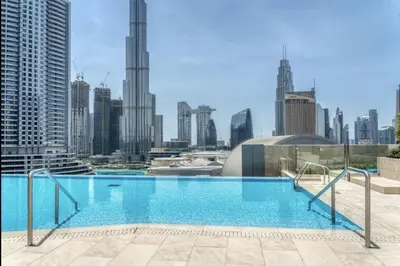 a large swimming pool with a city skyline in the background at Burj View Infinity Pool - Dubai Mall Connection in Dubai