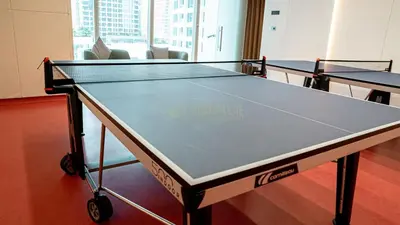 a ping pong table in a room with two tables at High Floor Brand New Apartment - 34 in Dubai