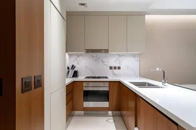 a kitchen with white cabinets and a stove top oven at Address Emaar Flagship Burj Khalifa Fountain view UPSCALE in Dubai