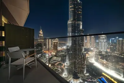 a balcony with a view of a city at night at Address Emaar Flagship Burj Khalifa Fountain view UPSCALE in Dubai