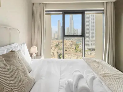 a bedroom with a white bed and a large window at Luxury - Fountain Show & Burj Khalifa View - 2 BR - 3 beds in Dubai