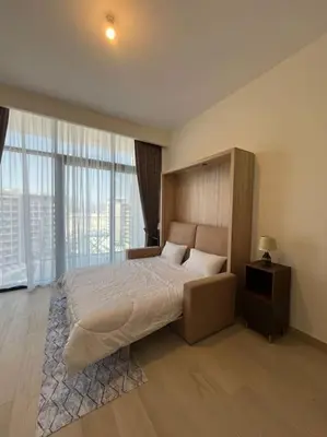 a bedroom with a large bed and a large window at Lovely Studio, Azizi Riviera in Dubai