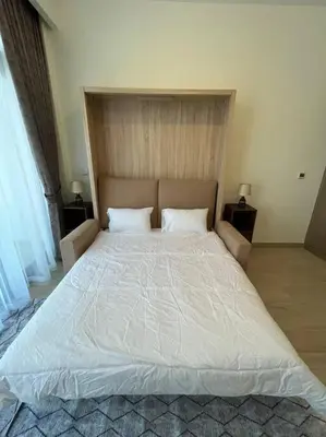 a large white bed in a bedroom with two pillows at Lovely Studio, Azizi Riviera in Dubai
