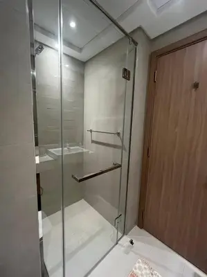 a glass shower in a bathroom with a sink at Lovely Studio, Azizi Riviera in Dubai