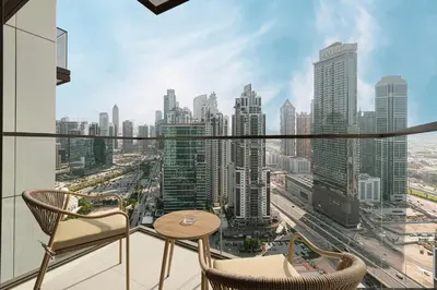 a balcony with chairs and a view of a city at Luxury Minimalistic Apartment in Downtown Dubai Opposite Burj Khalifa & Dubai Mall in Dubai