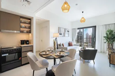 a kitchen and living room with a table and chairs at Luxury Minimalistic Apartment in Downtown Dubai Opposite Burj Khalifa & Dubai Mall in Dubai