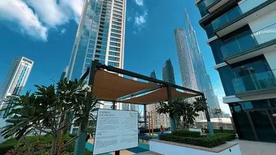 a sign in the middle of a city with tall buildings at Luxury Minimalistic Apartment in Downtown Dubai Opposite Burj Khalifa & Dubai Mall in Dubai