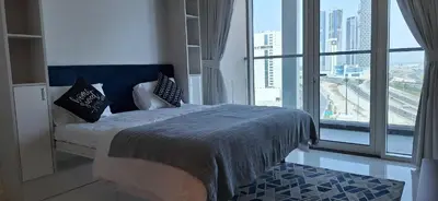 a bedroom with a bed and a large window at Bayz by Danube Marasi Drive in Dubai