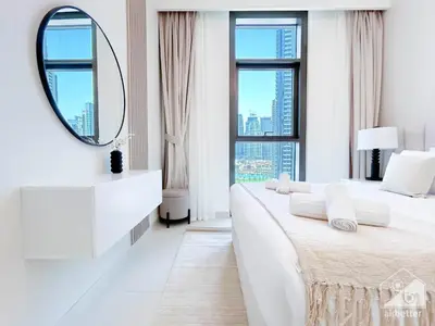a white bedroom with two beds and a mirror at Luxury Burj Crown Downtown Balcony & View in Dubai
