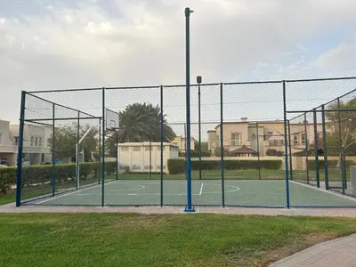 a tennis court with a net on a court at Elegant lakeside villa with a private pool in Dubai
