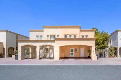 a large house with a garage on a street at Elegant lakeside villa with a private pool in Dubai