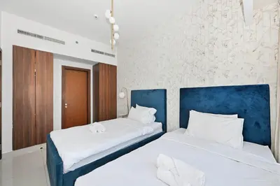 two beds in a bedroom with a blue headboard at Stunning Canal Views l Sleeps 6 in Dubai