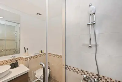a bathroom with a shower and a toilet and a sink at Stunning Canal Views l Sleeps 6 in Dubai