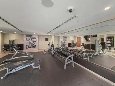 a gym with several tread machines and a mirror at Stunning Canal Views l Sleeps 6 in Dubai