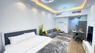a bedroom with a large bed and a living room at Dubai Marina - Modern Classic Studio Apartment in Dubai