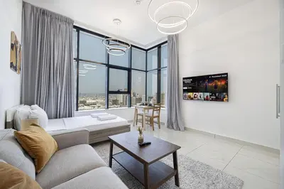 a living room with a couch and a table at LUXE | Studio in JVC | Cozy and Stylish in Dubai
