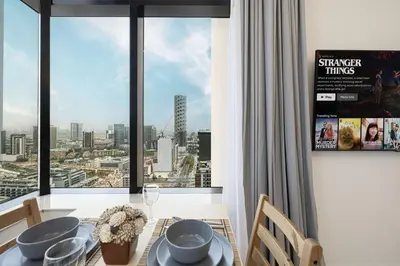 a dining room with a view of a city at LUXE | Studio in JVC | Cozy and Stylish in Dubai