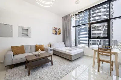 a living room with a couch and a table at LUXE | Studio in JVC | Cozy and Stylish in Dubai