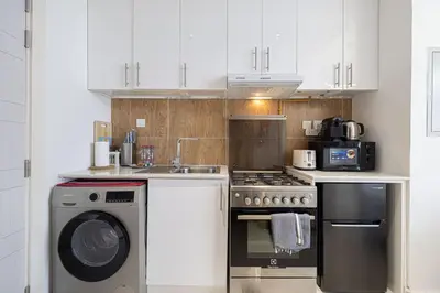 a kitchen with a stove and a dishwasher at LUXE | Studio in JVC | Cozy and Stylish in Dubai