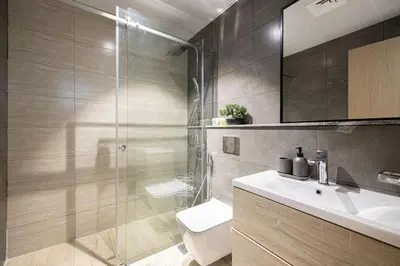 a bathroom with a shower and a toilet and a sink at LUXE | Studio in JVC | Cozy and Stylish in Dubai
