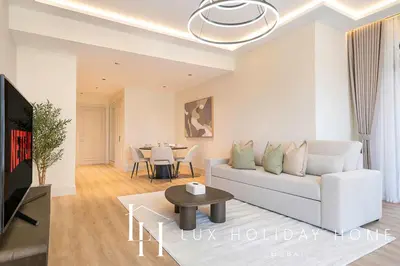 a living room with a white couch and a table at LUX The Burj Khalifa View Downtown Suite in Dubai