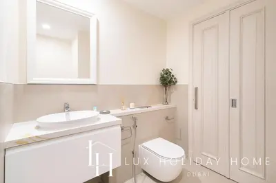 a bathroom with a toilet and a sink and a mirror at LUX The Burj Khalifa View Downtown Suite in Dubai