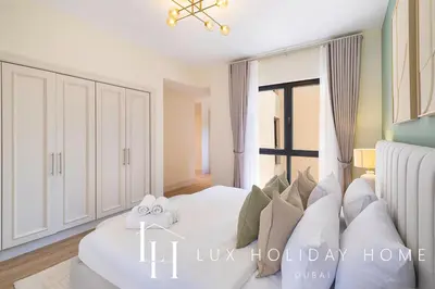 a bedroom with a white bed and a window at LUX The Burj Khalifa View Downtown Suite in Dubai