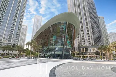 a glass building in a city with tall buildings at LUX The Burj Khalifa View Downtown Suite in Dubai