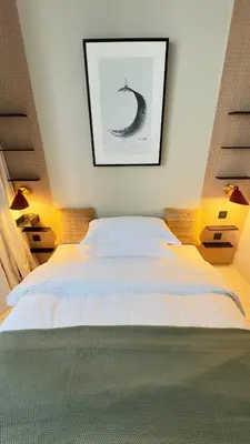a bedroom with a white bed with a picture on the wall at Stylish apartment in the center!10 minutes to Dubai mall and World Trade Center in Dubai