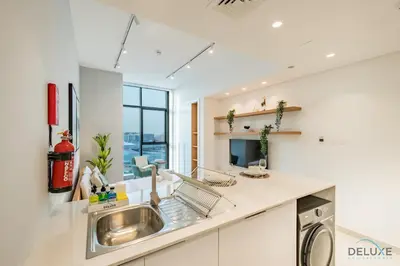 a kitchen with a sink and a dishwasher at Stylish Studio Apartment in Blue Wave Tower, Dubailand by Deluxe Holiday Homes in Dubai
